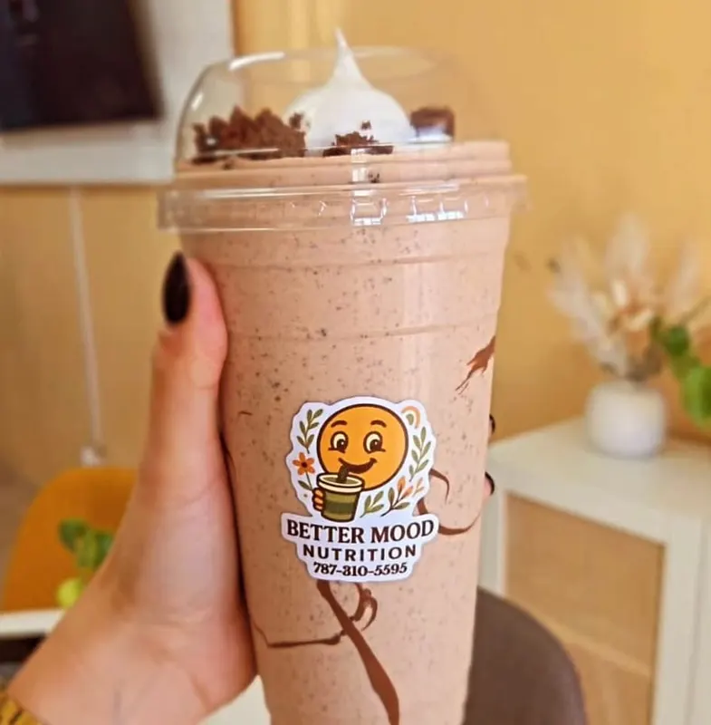 Mano sosteniendo un vaso con el sticker die cut de un cliente ya pegado